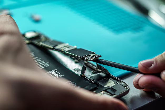Technician performing a board-level micro-repair on an Apple logic board